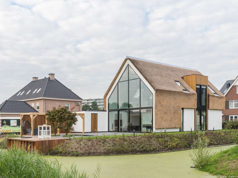 Moderne villa met gestucte gevels en rieten kap