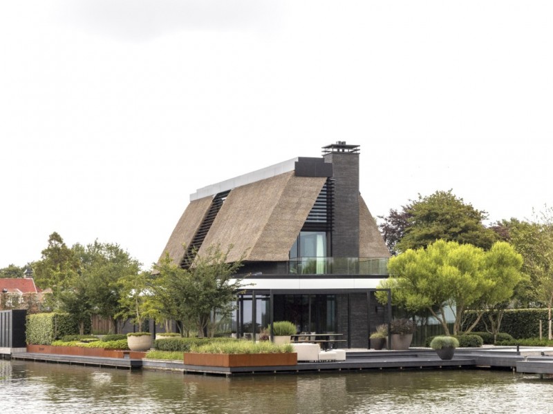 Rietgedekte villa aan het water